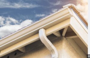 "Corner section of a seamless gutter with a downspout, showcasing a smooth and durable finish designed for efficient water drainage.