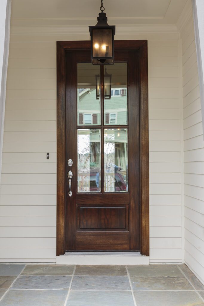 Wooden front door of family home with light fixture